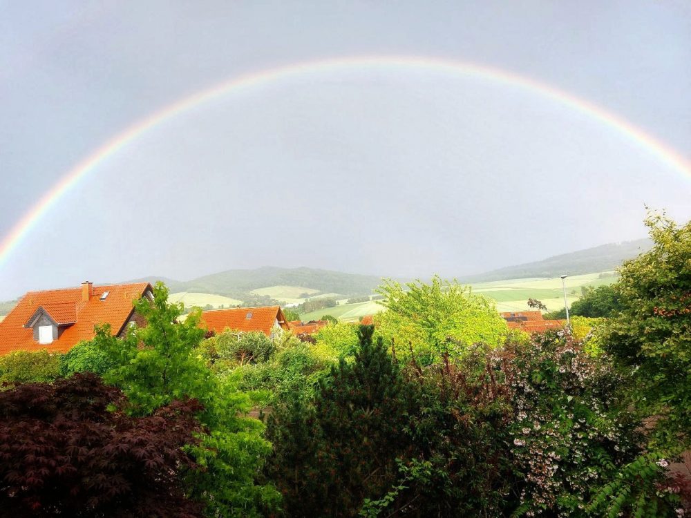 Gartenblick mit Regenbogen am Himmel